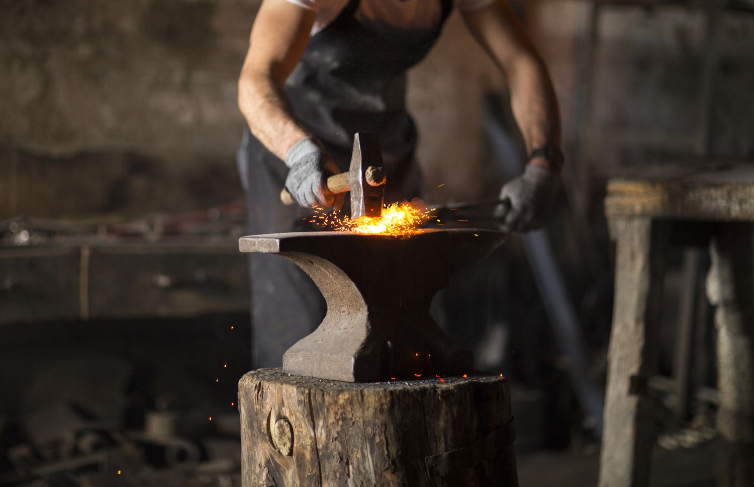 Blacksmith manually forging the molten metal