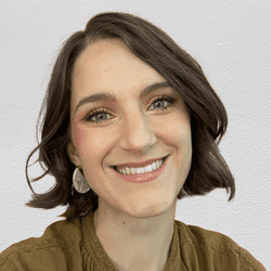 A photograph shows writer Elyssa Kirkham. She's smiling and poses in front of a textured, off-white background.