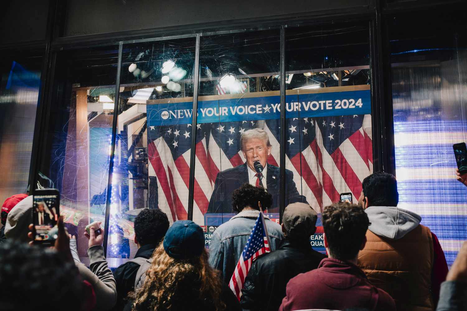 Onlookers watch a broadcast of former US President Donald Trump addressing his election night watch party, in Times Square in New York on Nov. 6, 2024 