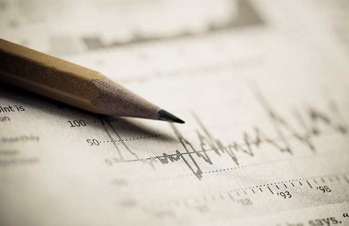 Close-up of pencil lying on paper with graphs on it