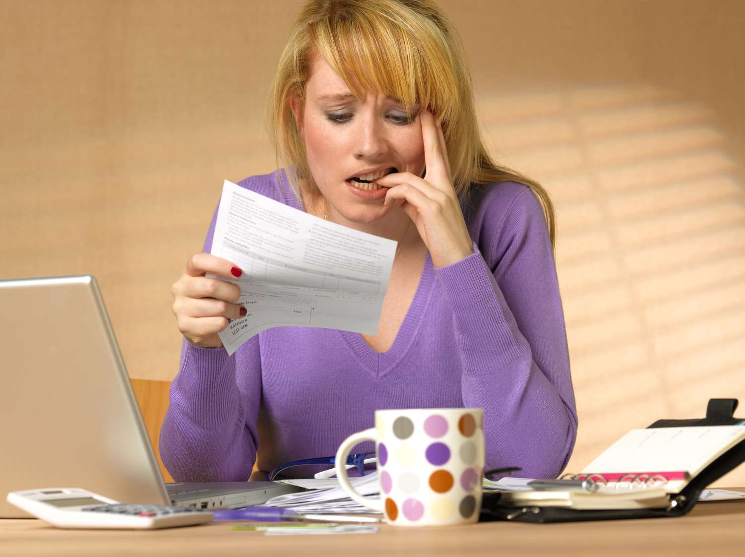 A person at a desk looks flummoxed looking at a tax bill.