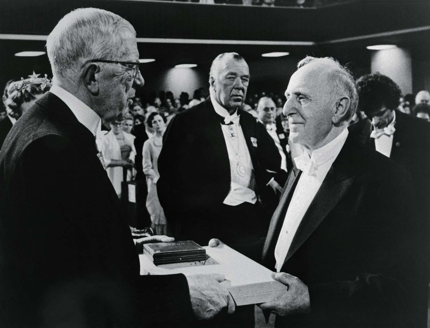 Russian born Simon S. Kuznets, (right) of Harvard University accepts his Nobel Prize in Economics from Sweden's King Gustav Adolf in a Pentecostal church rented for the occasion.