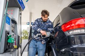 A customer pumps gas at a Chevron gas station.