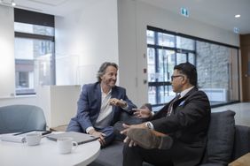 Smiling client talking with financial advisor in bank branch lobby about CD rates