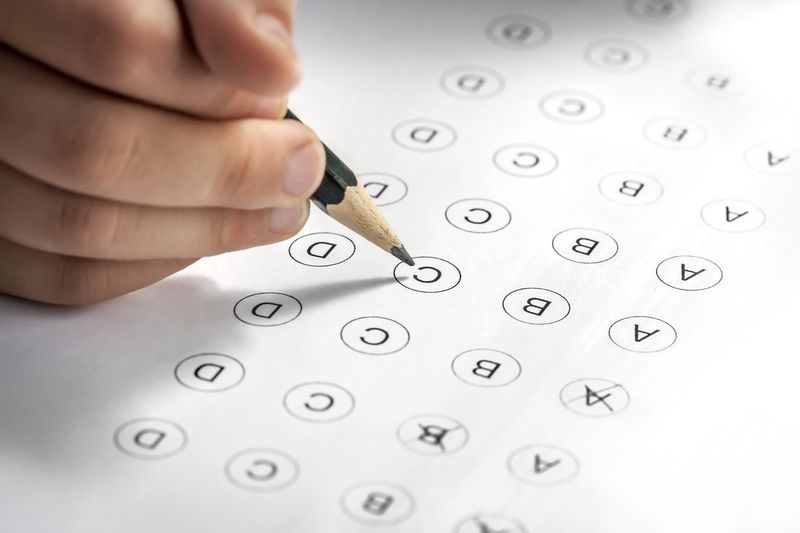 hand filling in a multi-answer test with a pencil