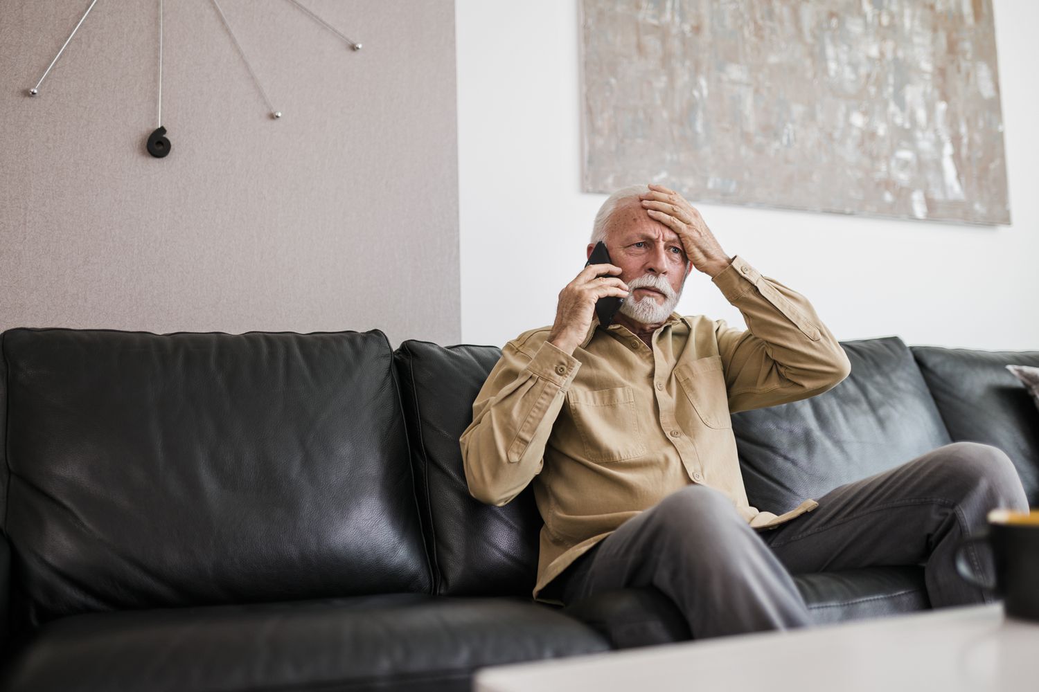 Upset man sitting on sofa with phone