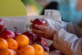 A shopper browses apples and fruit at a market in the Chinatown neighborhood in San Francisco