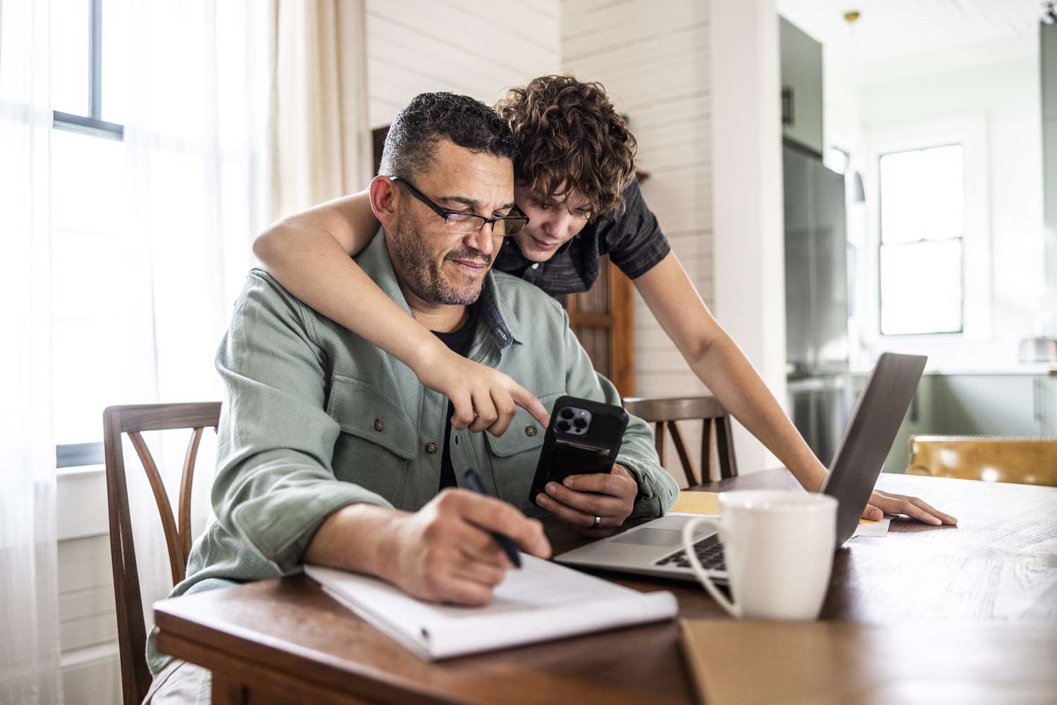 Father with teenage son and laptop