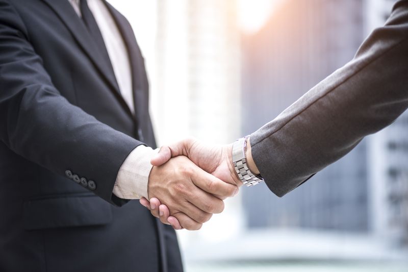 Two people shake hands.
