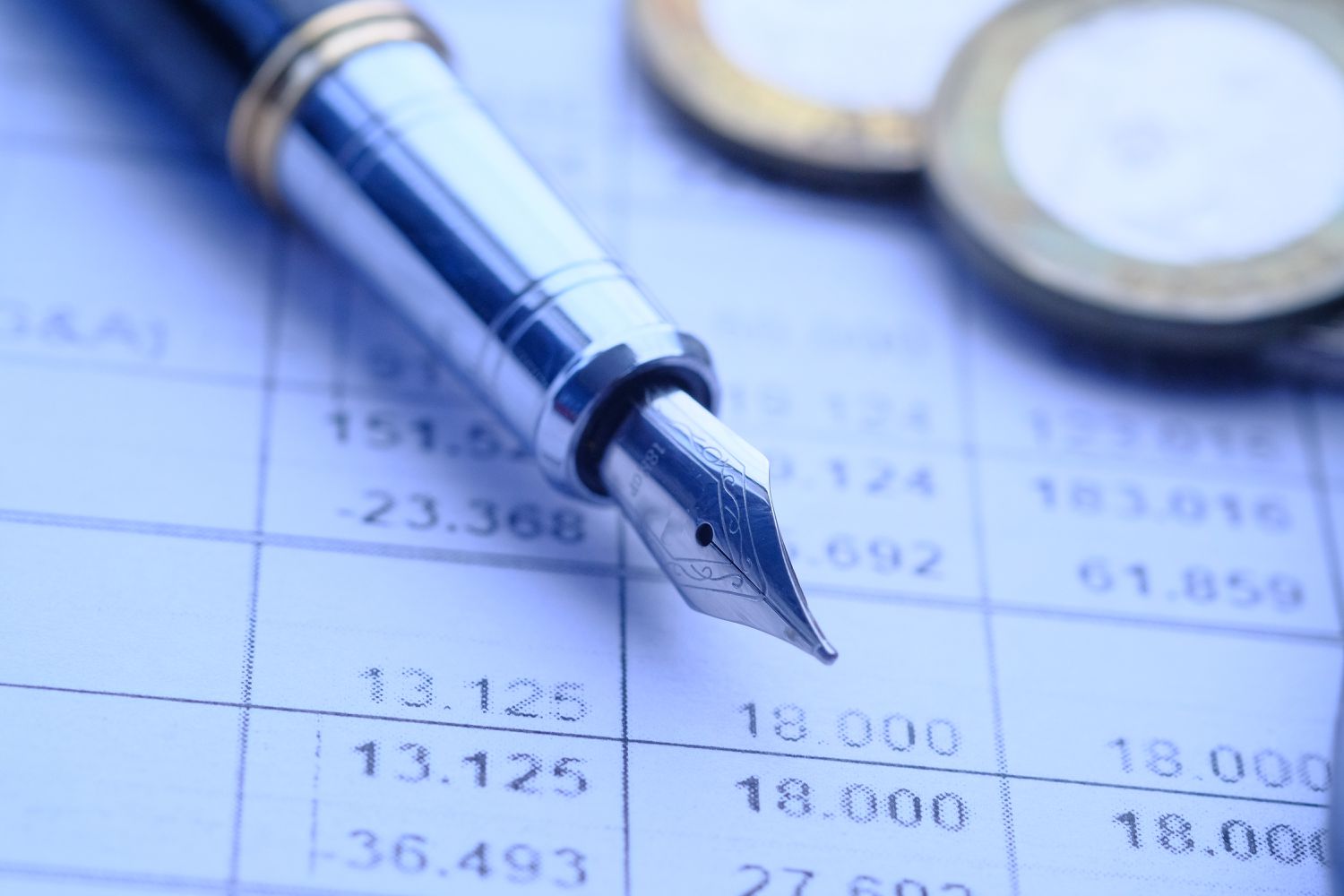 Pen and coins on financial statement