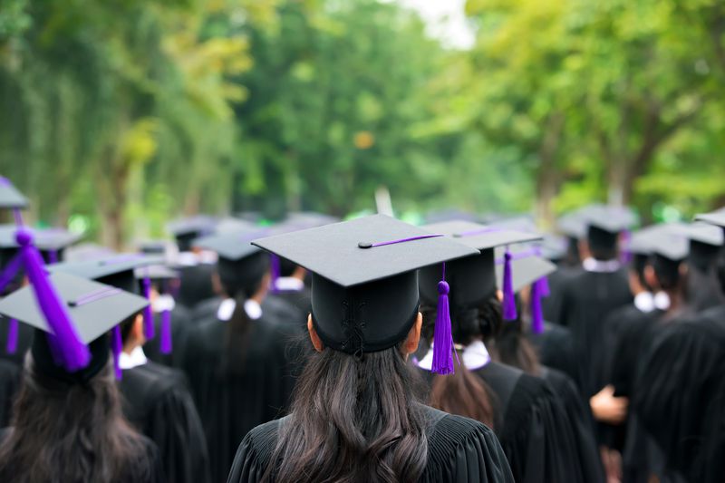 Students stand at graduation ceremony in caps and gowns