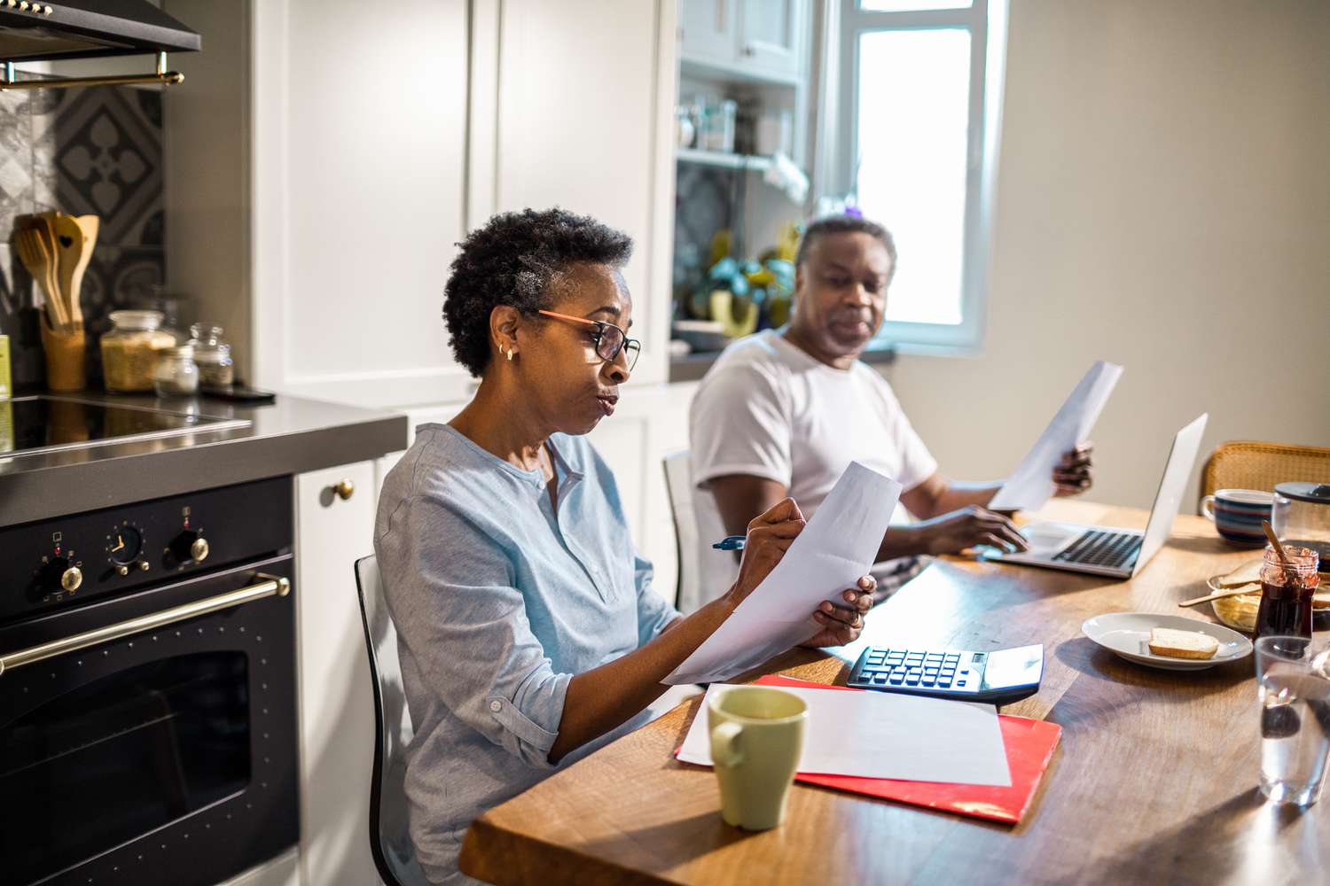 Senior couple going over their finances at the kitchen table