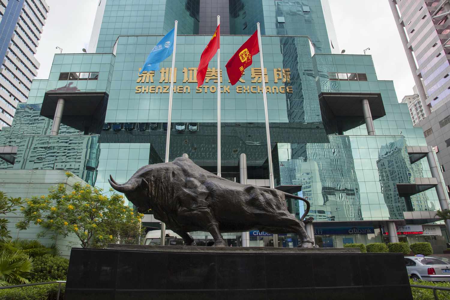 The Shenzhen stock exchange building with a statue of a bull in front
