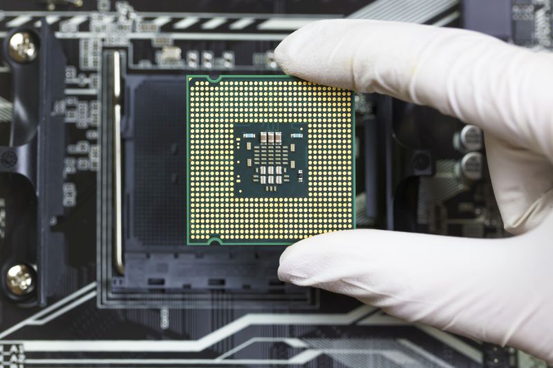 Human hand to installing an integrated circuit in a CPU