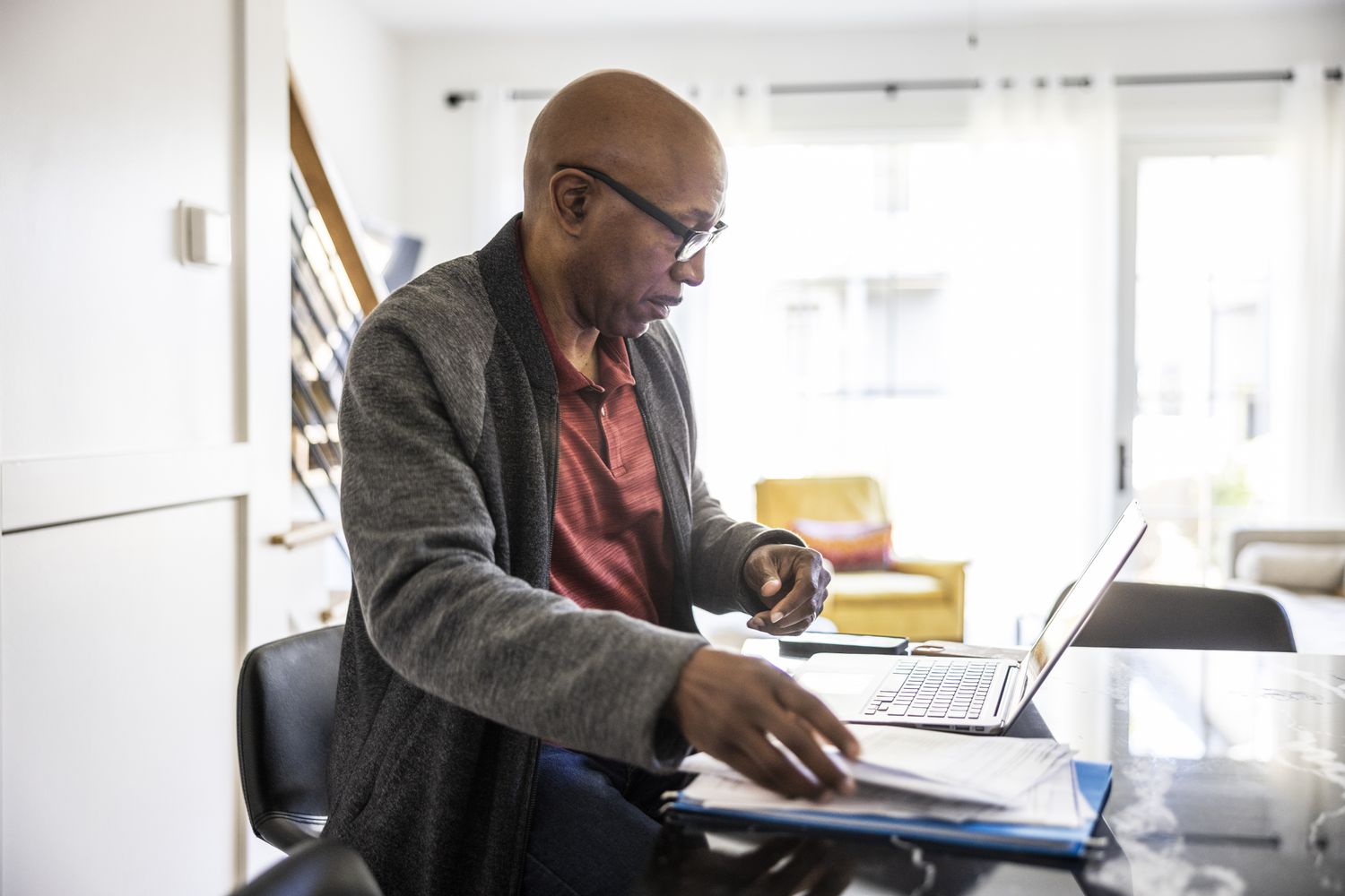 An older adult uses a laptop in their home office to work on their estate planning.