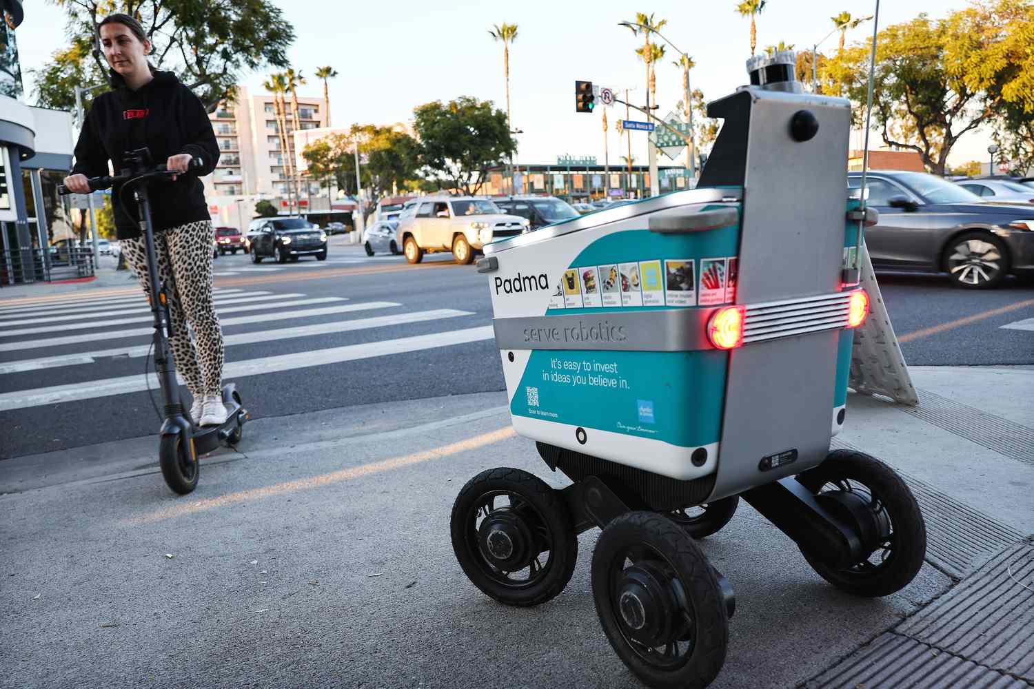 A Serve Robotics autonomous delivery robot, which utilizes AI and is emissions-free, waits at a crosswalk on March 19, 2024 in West Hollywood, California.