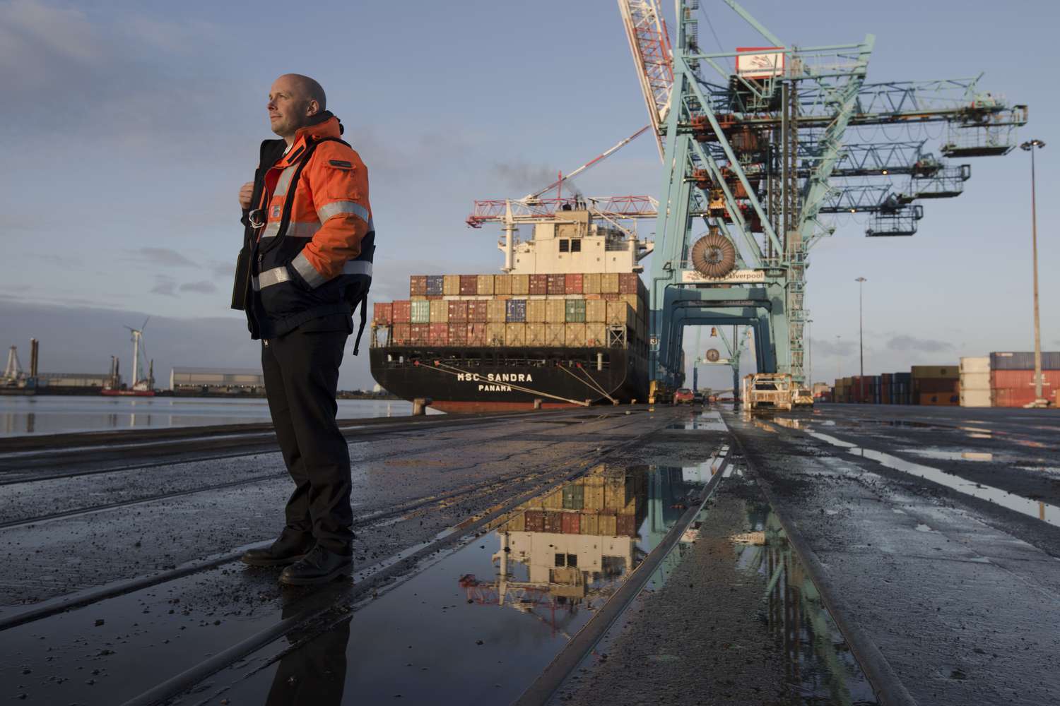James Smart, one of the team of Liverpool pilots employed by Liverpool Pilot Services Ltd to assist in the navigation of shipping in and out of Seaforth Docks and in the river Mersey, standing alongside the MSC Sandra. It was the pilot's job to navigate the 43,000 tonne container ship out of Seaforth Dock at the beginning of its voyage to Montreal, Quebec. Liverpool pilots such as James Smart were responsible for pilotage of thousands of vessels each year entering or leaving the post of Liverpool