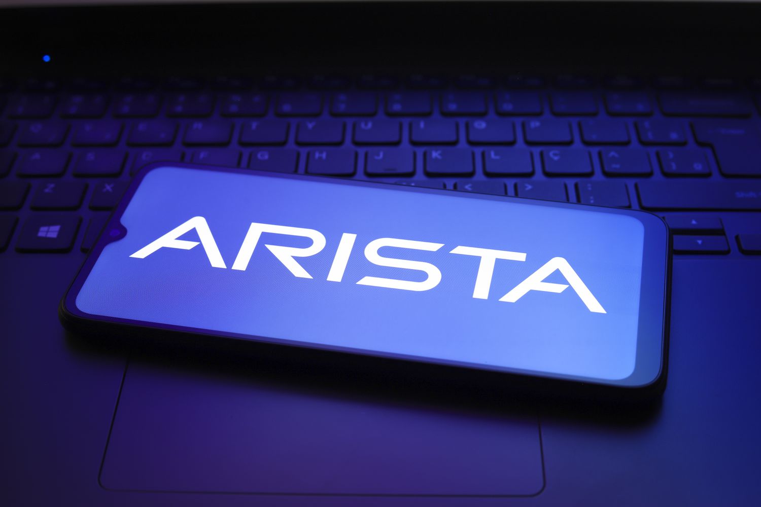 Arista logo on a smartphone that is setting on a keyboard.