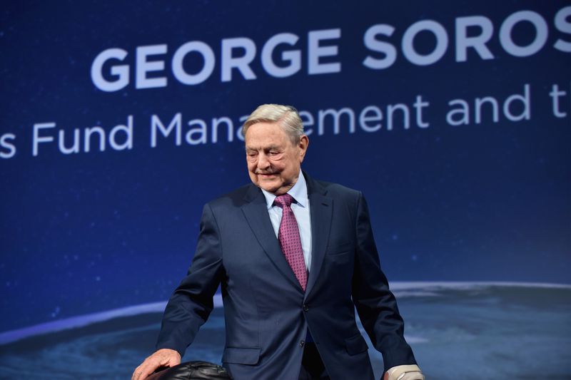 George Soros in 2016 in front of a poster for his investment fund