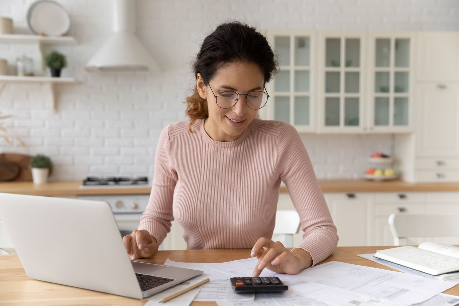 Worker at kitchen counter with a laptop