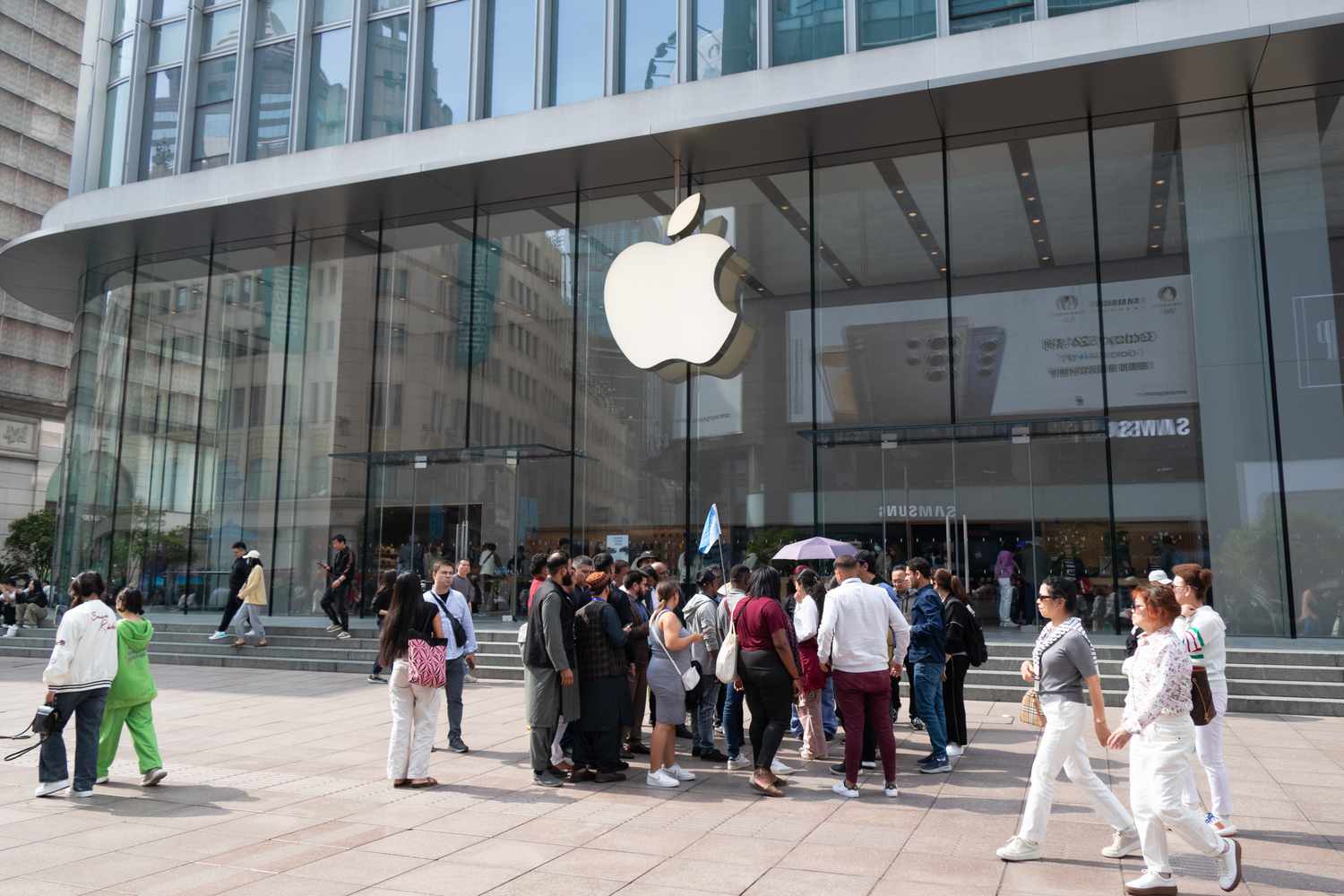 Foreign tourists are walking past an Apple store in Shanghai, China