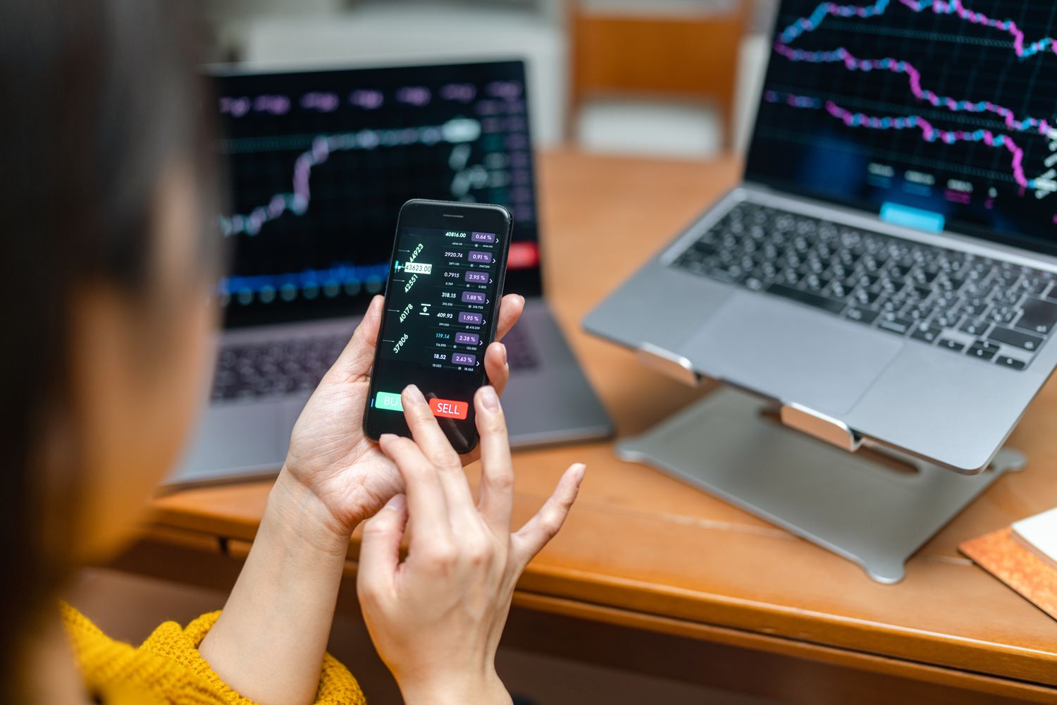 Trader hitting Buy button on mobile trading app.