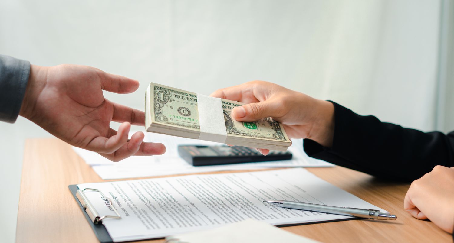 Lender giving cash to borrower in a subprime market loan.