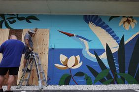 Men board up a bar in St. Petersburg, Fla., on Monday in preparation for Hurricane Milton. 