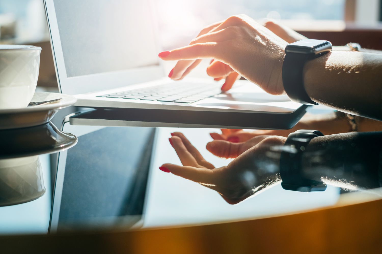 A close-up of a woman working on her laptop.