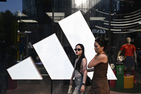 People walk past an Adidas store at a mall in Beijing on June 16, 2024. 