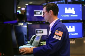 A trader faces a computer screen, working on the floor of the New York Stock Exchange.