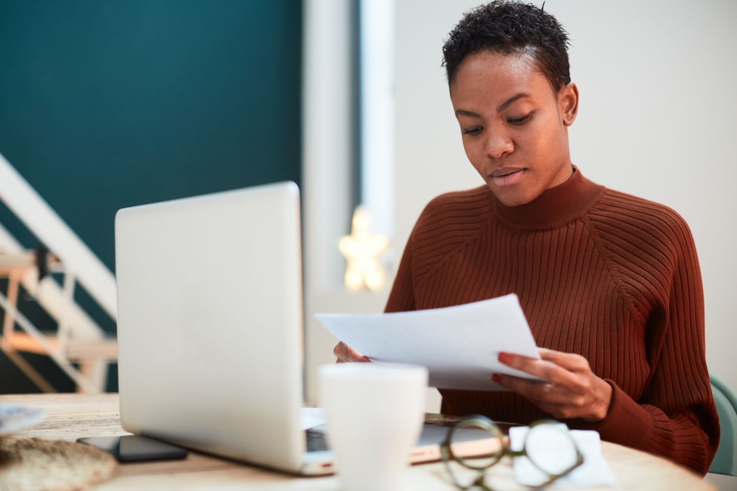 Woman working on her finances at home, filling up tax forms