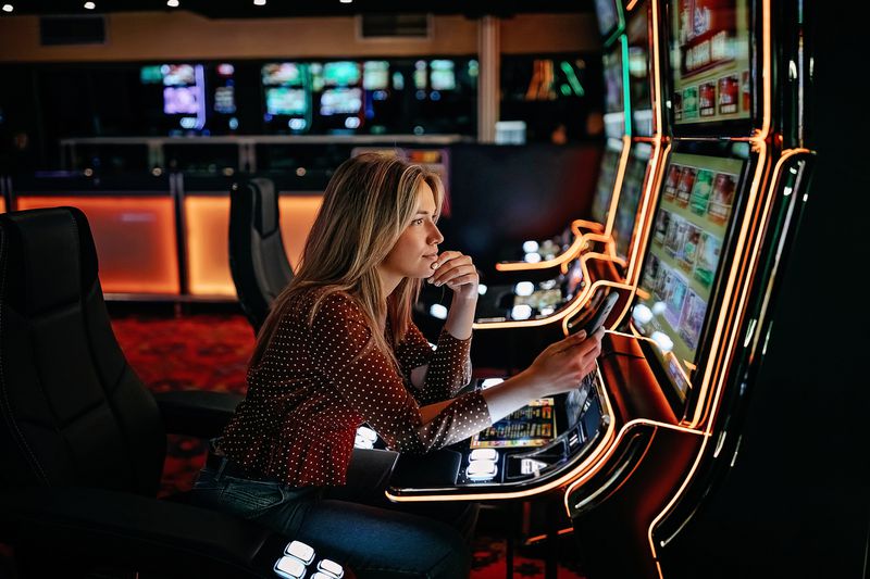 A woman plays machines at a casino.