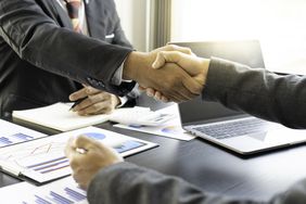 A hand shake over a desk