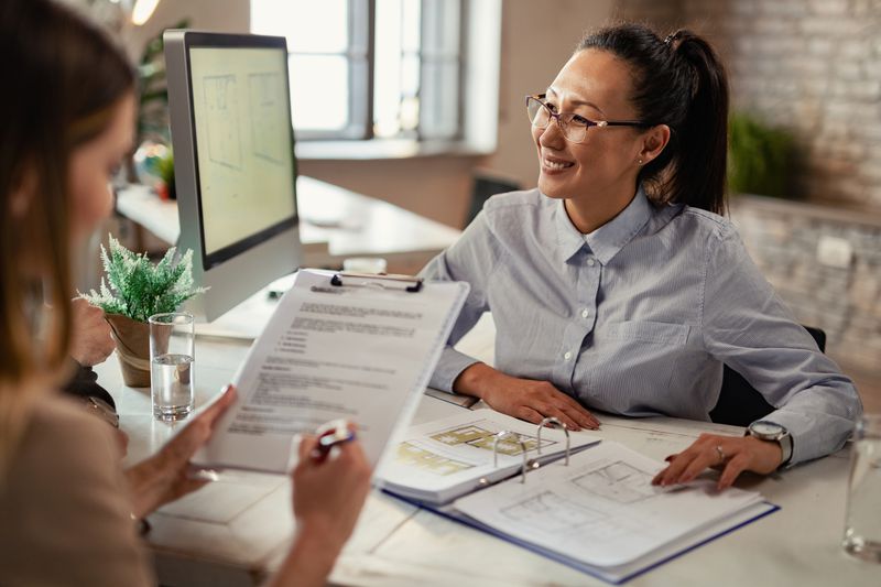 Lender talking with a borrower client during a meeting in the office.