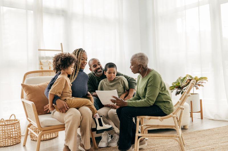 Mother, father, and children discuss financial planning with grandmother. 