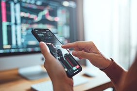 Woman is checking Bitcoin price chart on digital exchange on smartphone, cryptocurrency future price action prediction. Another crisis is coming and prices on the charts are falling down.