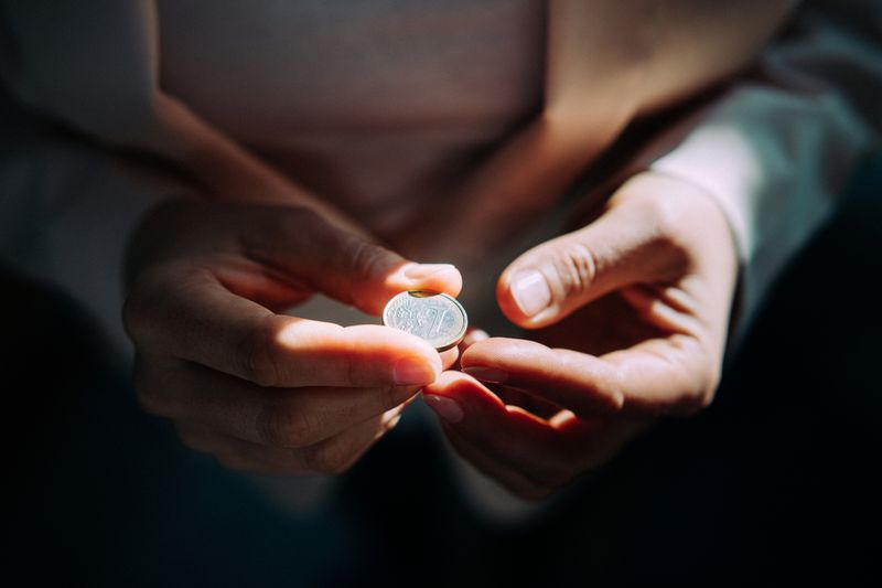 A Person Holds a Coin