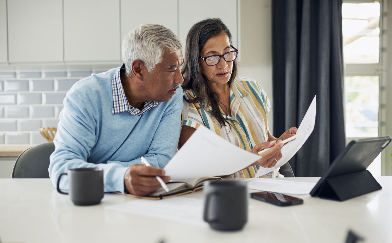 Couple sitting at a table reviewing paperwork.
