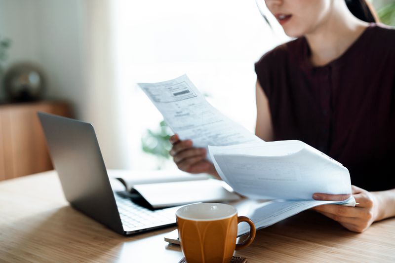 woman making financial plan and planning budget as she go through her financial bills, tax and expenses at home