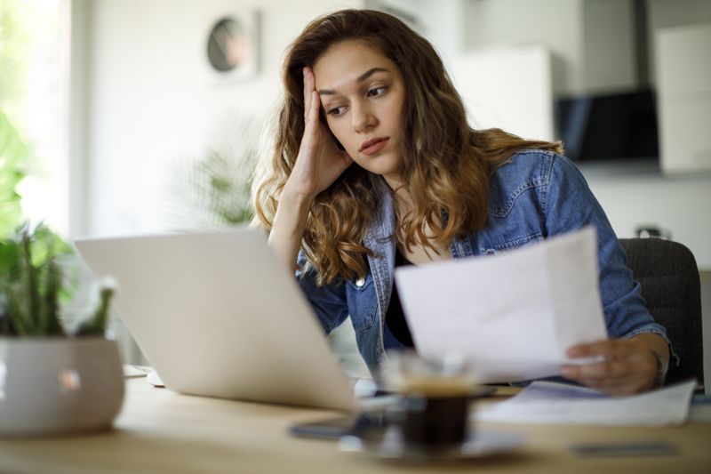 Woman looking a bit worries as she looks at her finances.