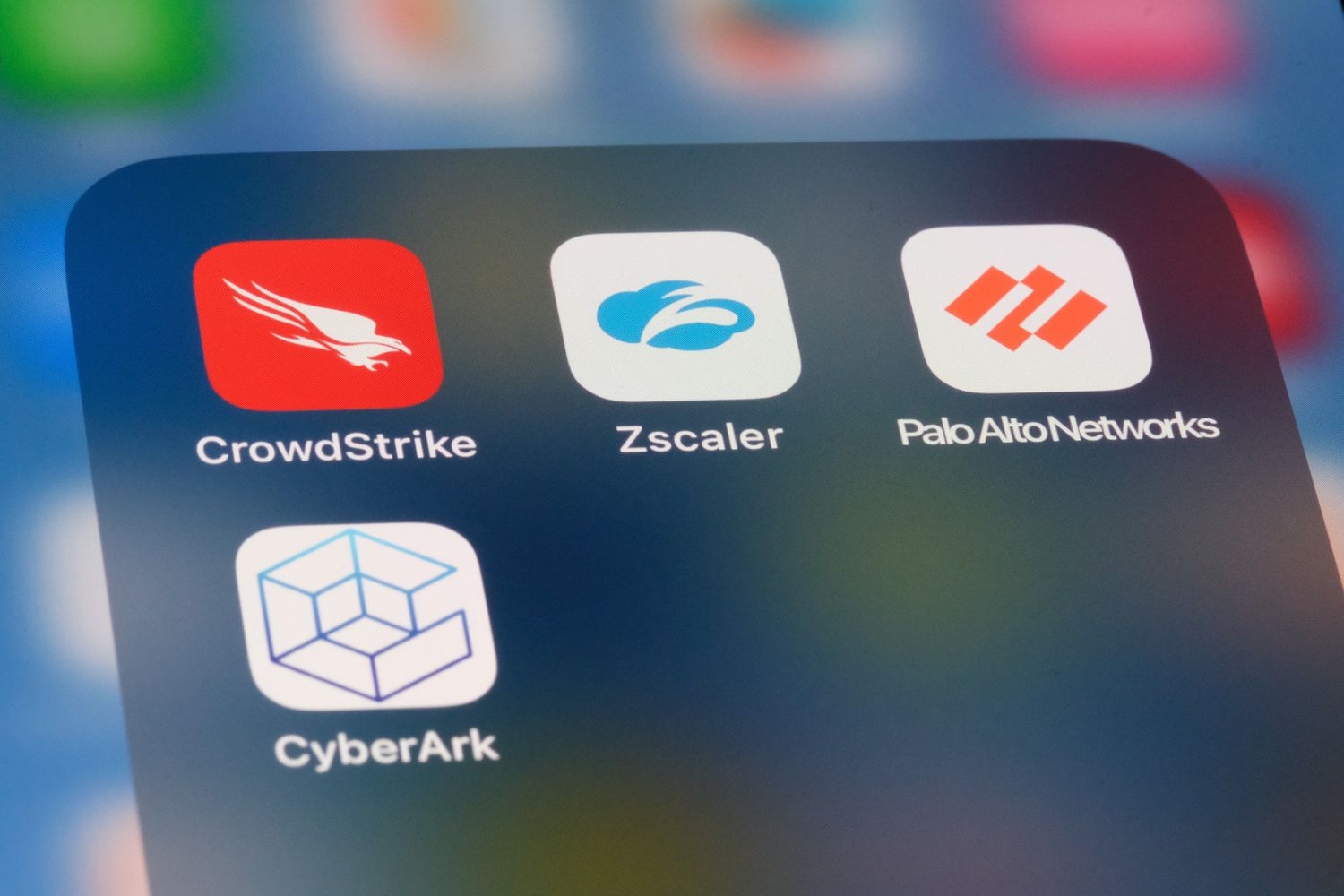 Zscaler, CrowdStrike, Palo Alto Networks, and CyberArk logos on an iPhone display. 