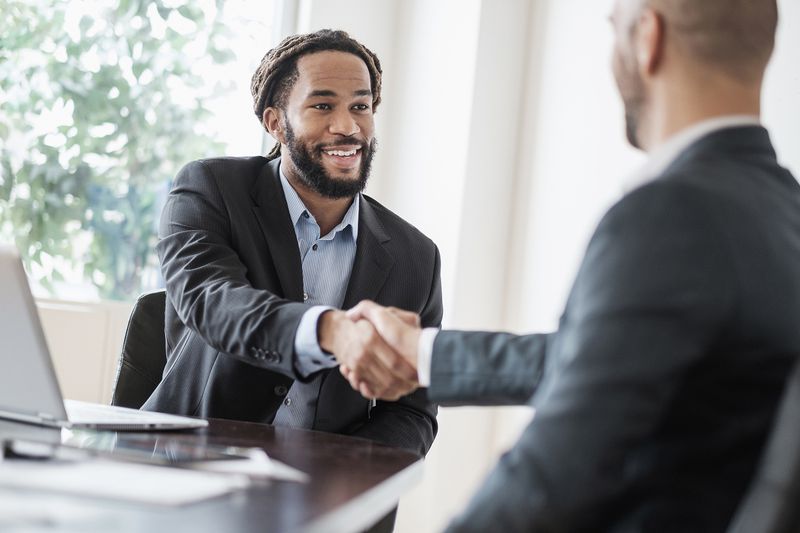 Smiling Businessmen Shaking Hands in Office
