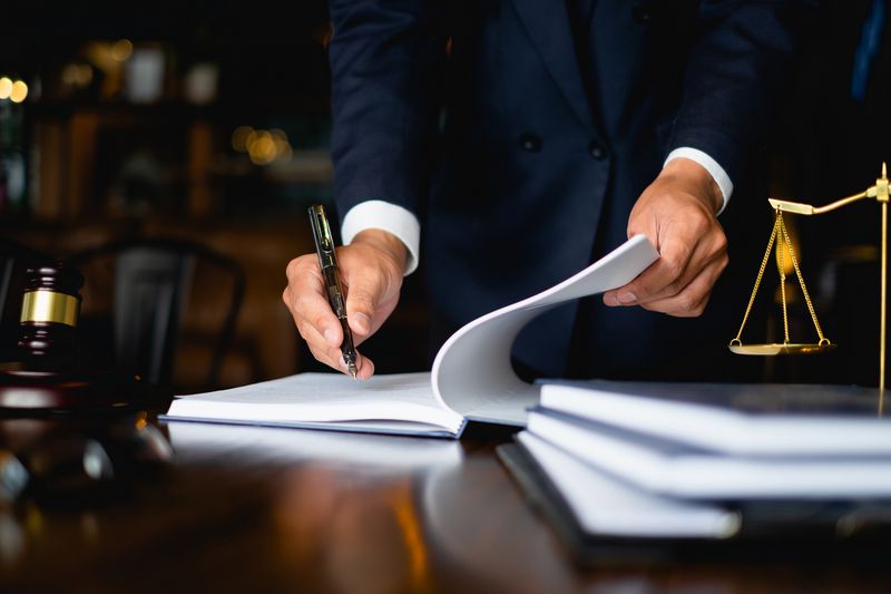 Close up lawyer businessman working or reading lawbook in office workplace.