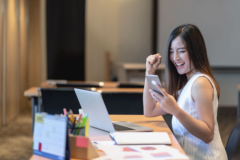 Businesswoman Excited While Looking at Phone