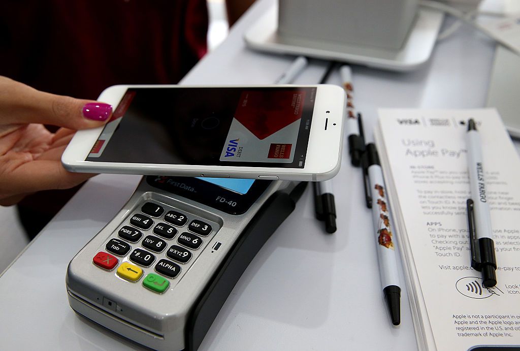 220,000 Stores Start Accepting Apple Pay SAN FRANCISCO, CA - OCTOBER 20: A worker demonstrates Apple Pay inside a mobile kiosk sponsored by Visa and Wells Fargo to demonstrate the new Apple Pay mobile payment system on October 20, 2014 in San Francisco City. Apple's Apple Pay mobile payment system launched today at select banks and retail outlets.