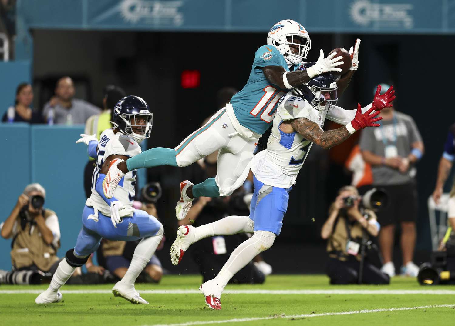 Miami Dolphins wide receiver Tyreek Hill jumps to catch a football over the head of Amani Hooker of the Tennessee Titans.