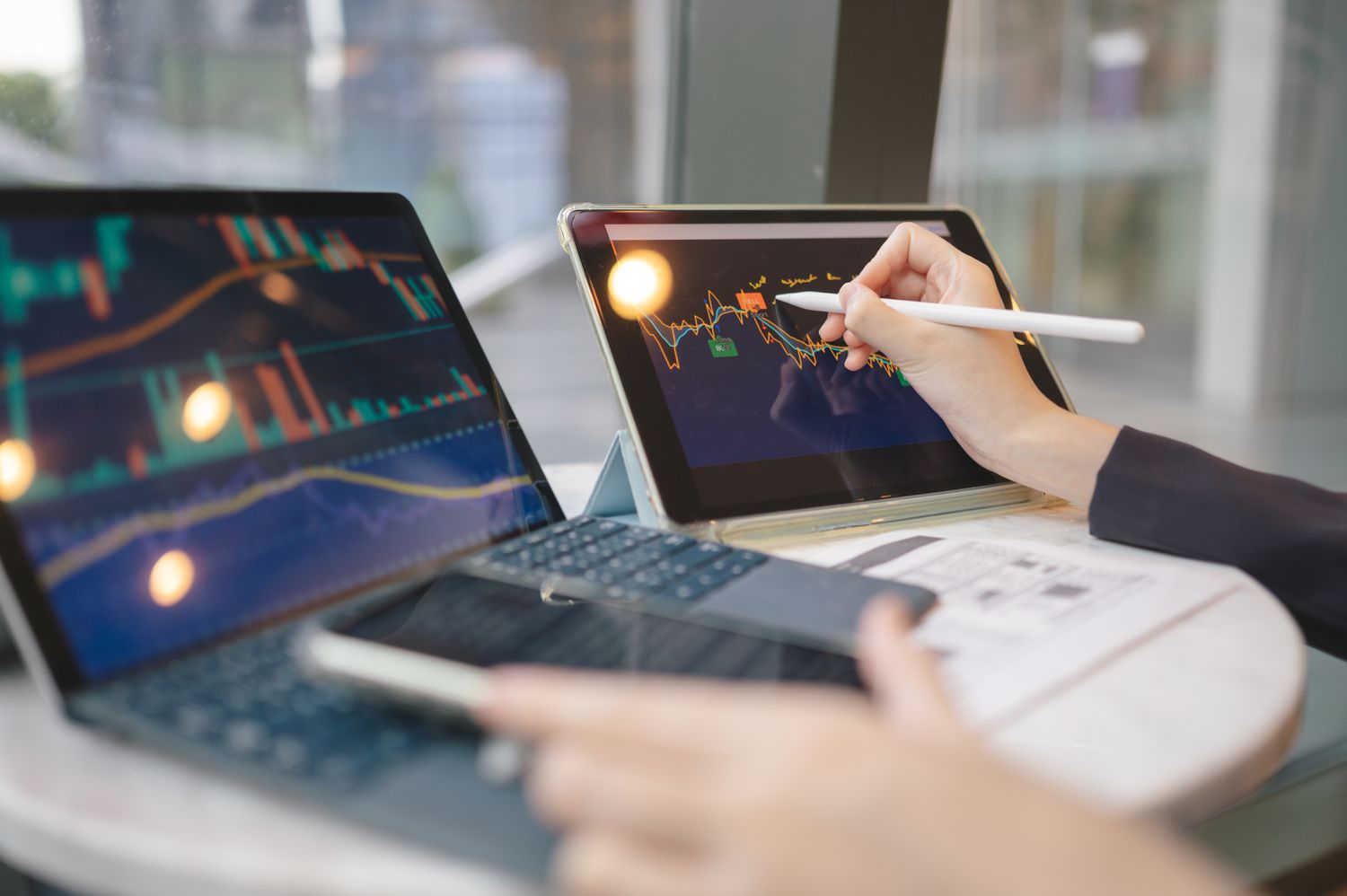 An investor compares data on two different computer screens looking for signs of a market top on the stock they follow.