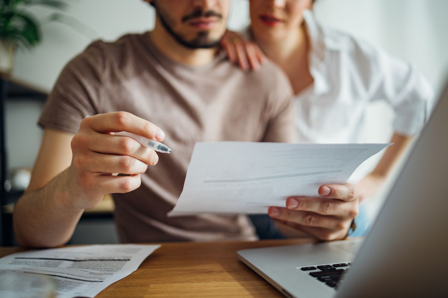 A couple sitting in front of a laptop making a plan to apply for a cross-collateral loan.