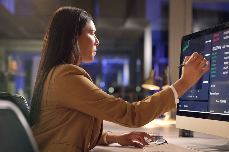 Woman looks at financial numbers on an office computer 